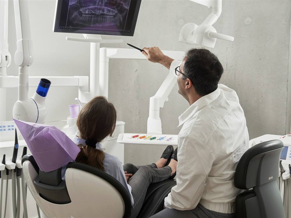 A periodontist explaining an X-ray to a patient